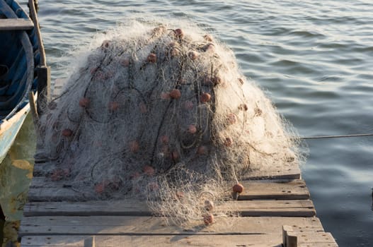 fishing net on the wooden jetty next to the boat