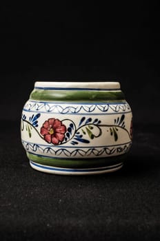 Colorful designed clay vase over a Black background