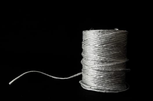 Roll of White Twine on a Black Background