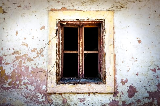 Detail of old damaged window on textured wall