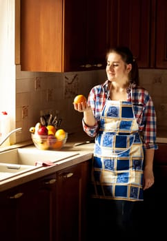 Portrait of happy housewife eating cucumbers from salad