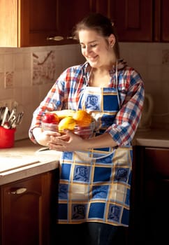 Portrait of happy housewife eating cucumbers from salad