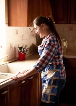 Portrait of housewife checking how clean is the glass bowl
