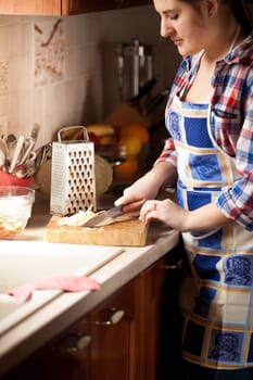 Closeup portrait of brunette woman cutting cabbage with knife