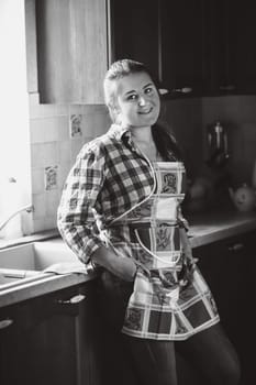 Black and white portrait of smiling housewife in apron