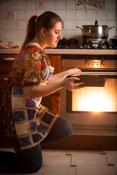 Closeup photo of housewife cooking cookies in oven