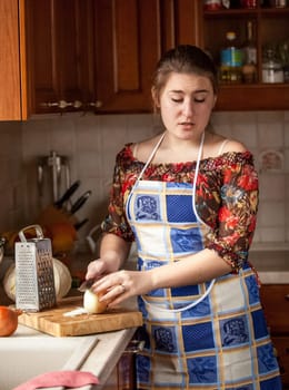 Brunette housewife crying while cutting onion