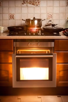 Photo of hot oven and pan boiling on stove at kitchen