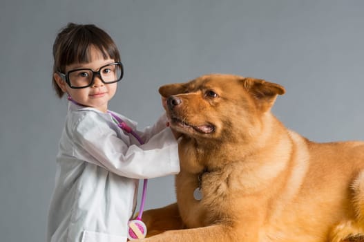 Child playing veterinarian with dog