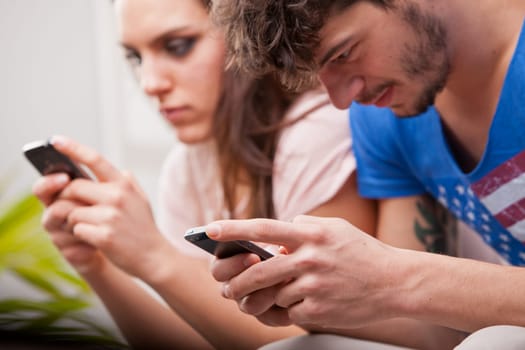 girl and boy looking at their mobile phones