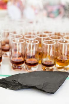 Closeup of glasses of fruity flavoured apertifs behind decorative stone