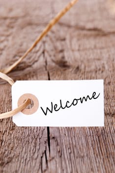 Natural Background with white Label on Wooden Plank with the Word Welcome on it, with Copy Space
