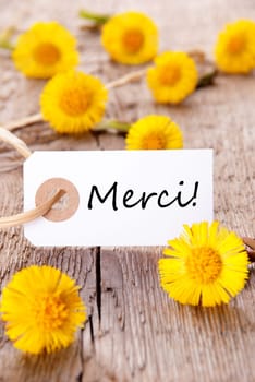 Yellow Flowers with Tag with the French Word Merci on it which means Thanks
