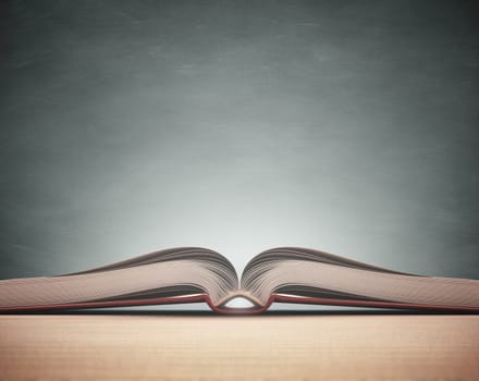 Open book over the table with blackboard on background. Clipping path included.