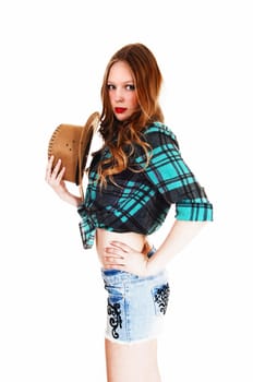 A lovely young teen girl in shorts and blouse holding a straw hat standing.isolated for white background..