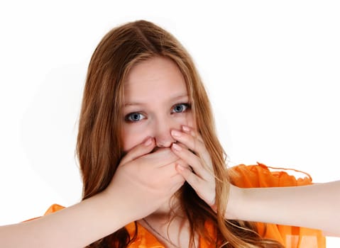 A lovely young woman holding her hands over her mouth, did say the.wrong thing, isolated for white background..