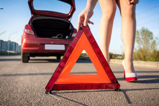 Closeup photo of sexy woman putting warning sign on road