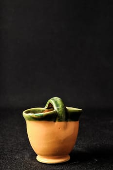 Colorful designed clay vase over a Black background