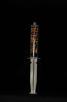 Medical Syringe Full of Pill Drugs on a Black Background