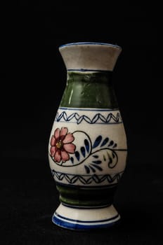 Colorful designed clay vase over a Black background