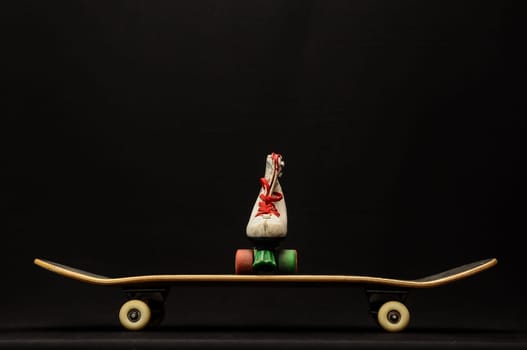 Vintage Style Black Skateboard and Skate Boot on a Dark Background