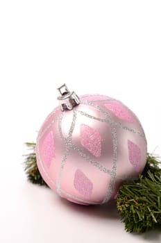Pink Christmas bauble with a green twig