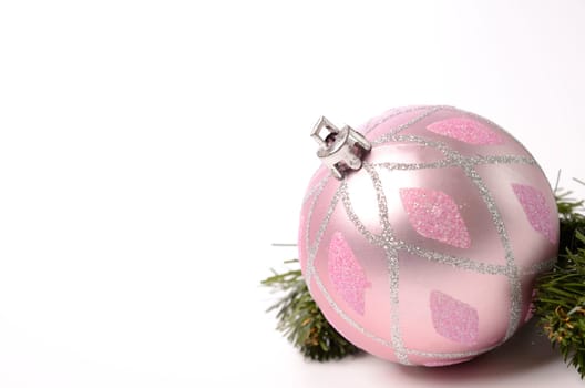 Pink Christmas bauble with a green twig