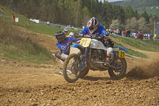 MOHELNICE, CZECH REPUBLIC - APRIL 19. Racers in blue are passing a sweep by sidecar in the "International Championship of Czech Republic 2014"" on April 19. 2014  in the town of Mohelnice, Czech Republic."