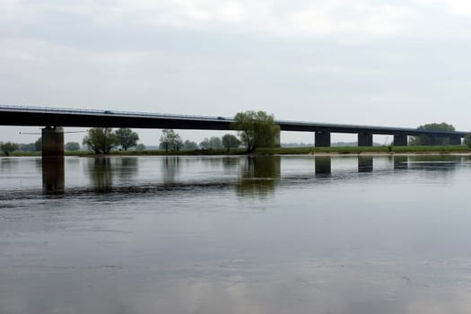 The Elbe Bridge near Wittenberge with reflections in the river Elbe and traffic.