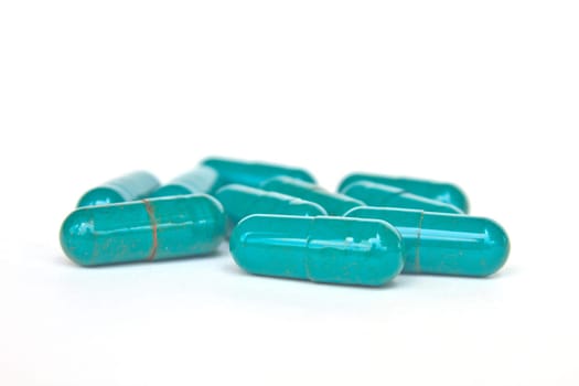 close up of green capsule isolated on white background