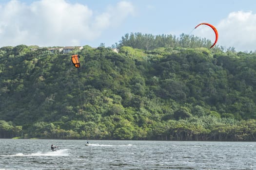 Kite surfing sport action in river lagoon waters and surf action Umdloti river lagoon north of Durban South Africa.