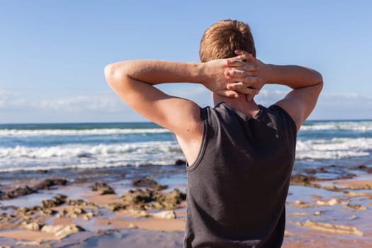 Teen boy unidentified hangout at the  beach ocean on clear blue day