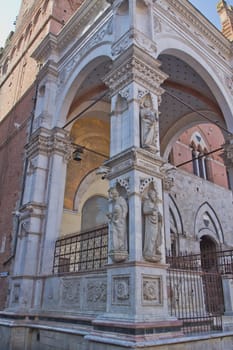The Torre del Mangia. Statues on loggia. (Siena,Tuscany, Italy).