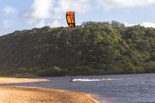 Kite surfing sport action in river lagoon waters and surf action Umdloti river lagoon north of Durban South Africa.