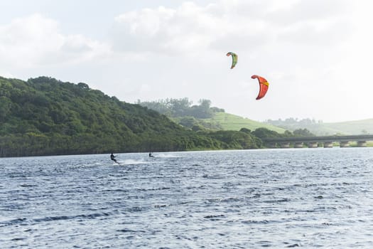 Kite surfing sport action in river lagoon waters and surf action Umdloti river lagoon north of Durban South Africa.