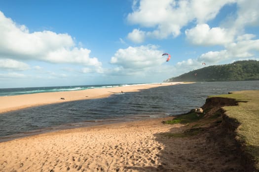 Kite surfing sport action in river lagoon waters and surf action Umdloti river lagoon north of Durban South Africa.