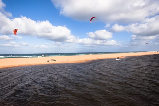 Kite surfing sport action in river lagoon waters and surf action Umdloti river lagoon north of Durban South Africa.