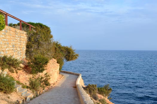 Paved coastal walkway on a summer evening, Cabo Roig, Costa Blanca, Spain