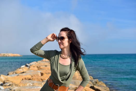 Young woman posing on a rocky beach in a beautiful summer evening, Costa Blanca, Spain