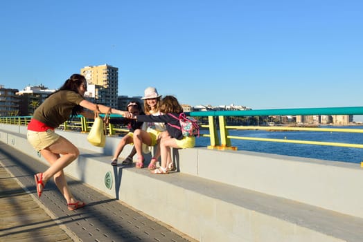 Young woman enjoying a summer evening on the beach with her girls, Costa Blanca, Spain