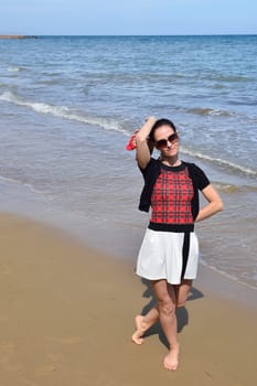 Young woman walking on the beach in the sand in a nice summer day, Costa Blanca, Spain