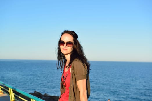 Young woman walking on the beach promenade on a beautiful summer evening, Costa Blanca, Spain