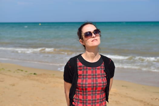 Young woman walking on the beach in the sand in a nice summer day, Costa Blanca, Spain