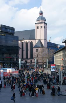 Cologne,Germany – March 02,2014: Colourfully dressed people walk to the carnival procession on the station forecourt in Cologne overlooking the St. Mary's Assumption Church on March 2,2014 in Cologne.