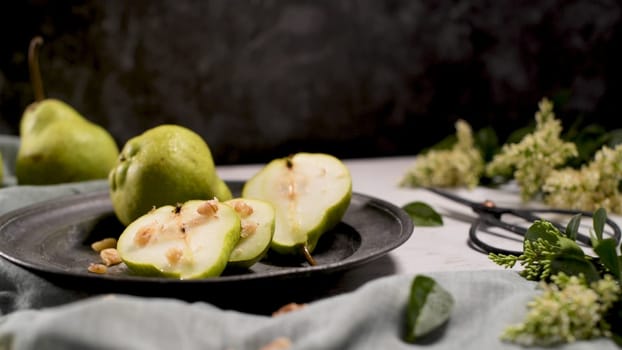 Metal plate with delicious ripe pears on table.