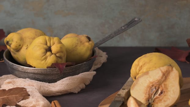 Quince fruits and marmalade in a ceramic bowl on table top.