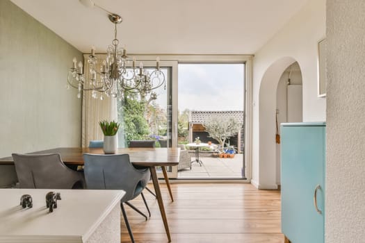 a kitchen and dining area in a house with an open door that leads to the outside patio, which has been used as a