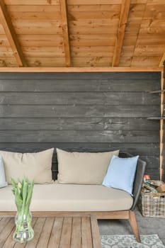 a living room with wood paneled walls and wooden flooring that has been used as an outdoor seating area