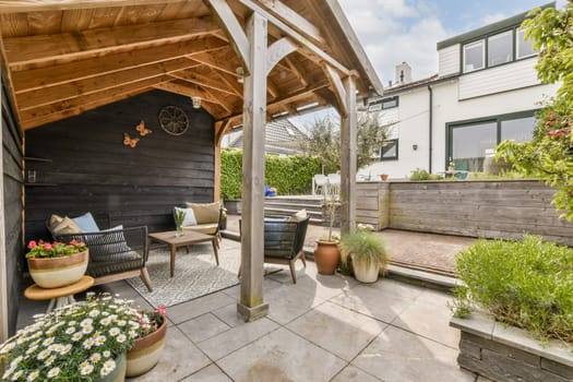 an outdoor living area with patio furniture and potted plants on the ground in front of the house, taken from above