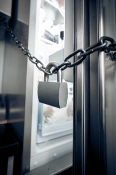 Closeup photo of metal lock hanging on refrigerator door